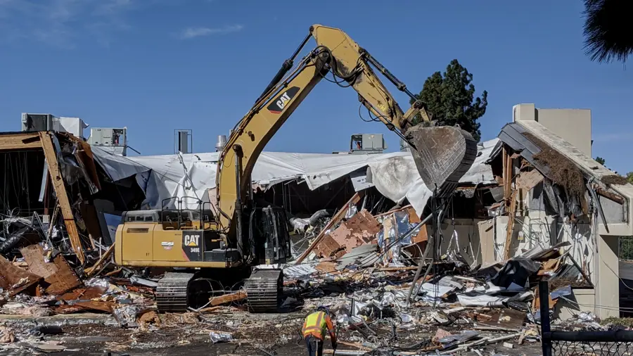Excavator demolishing a two-storey commercial building